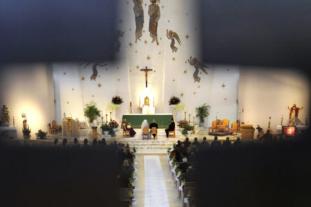 wedding viewed through a cross cutout